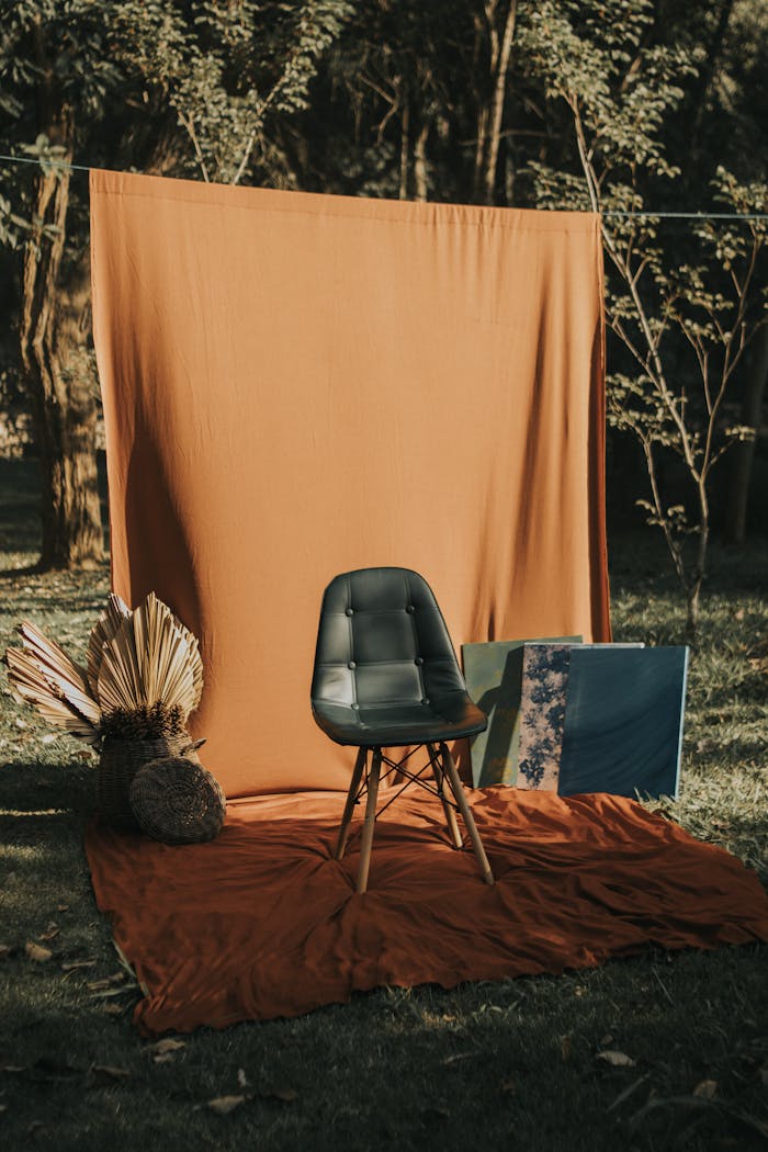 A stylish green chair set against a rustic outdoor backdrop with artistic decor.